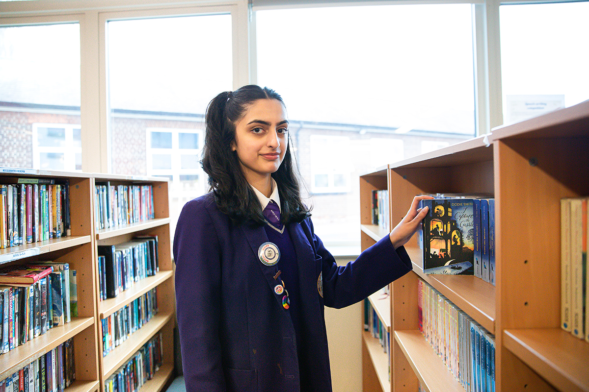 A student perusing books in the library